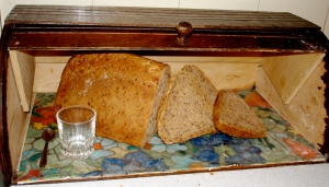 Bread box with bread, spoon and cup inside